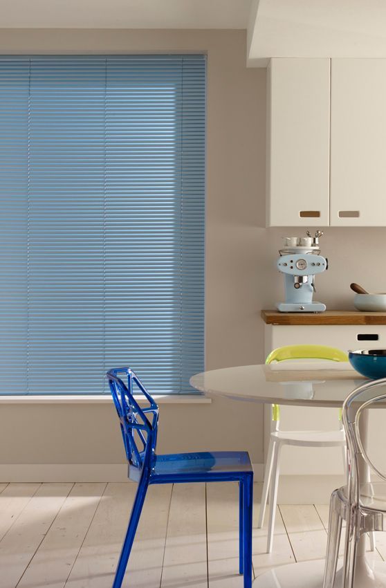 A kitchen with a table and chairs and a blue blind