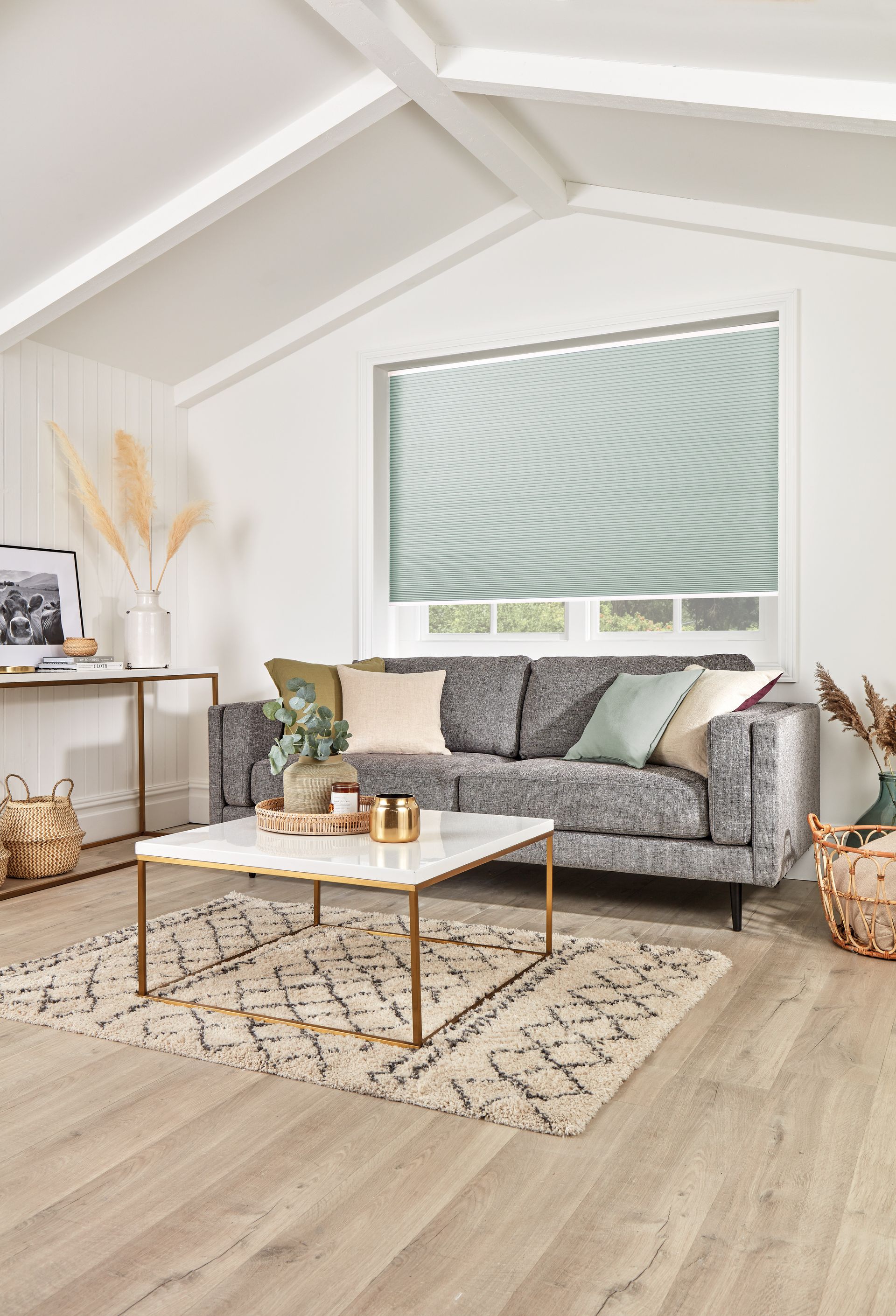 A living room with a couch , coffee table , rug and window.