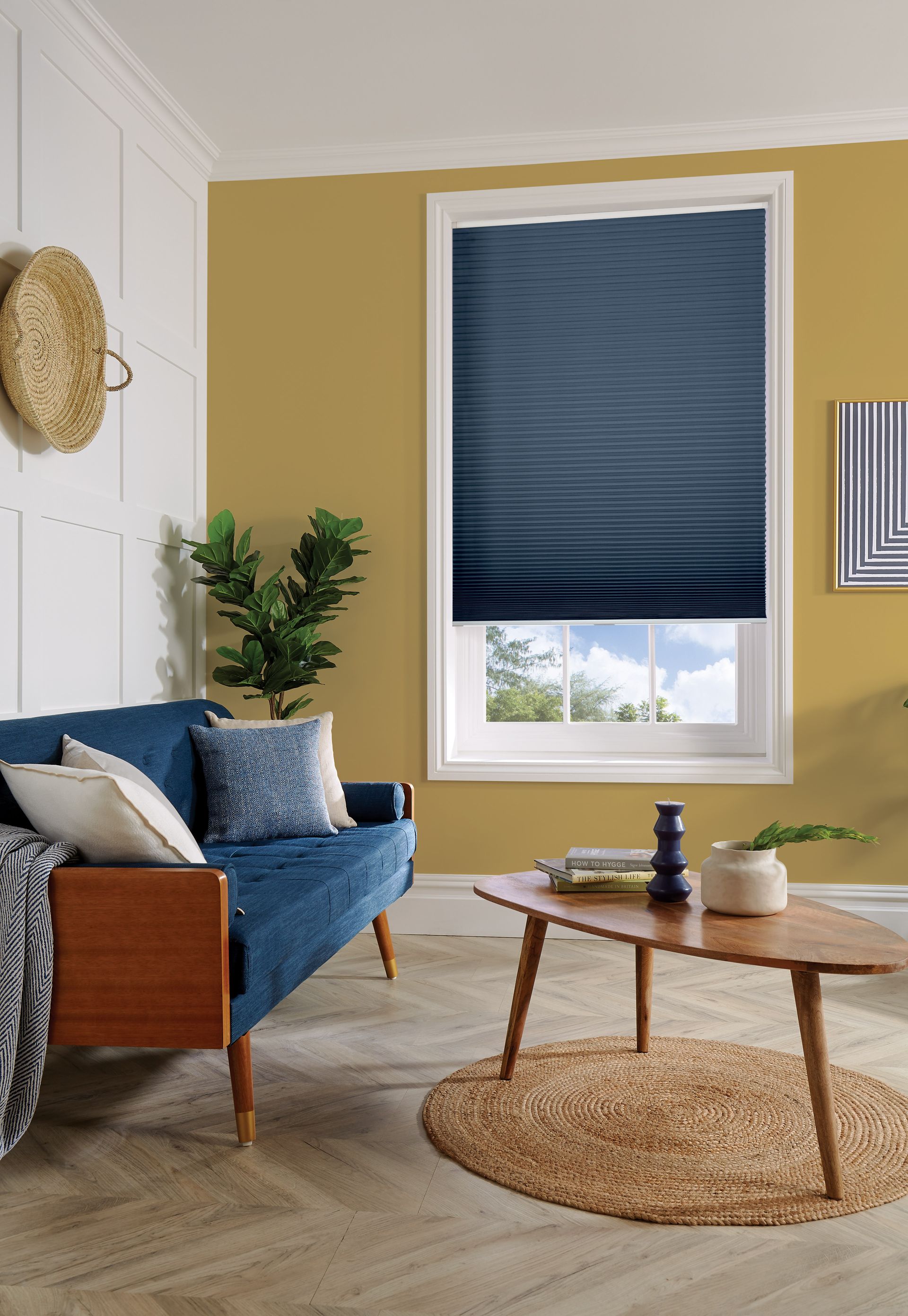 A living room with a blue couch , coffee table , and window.