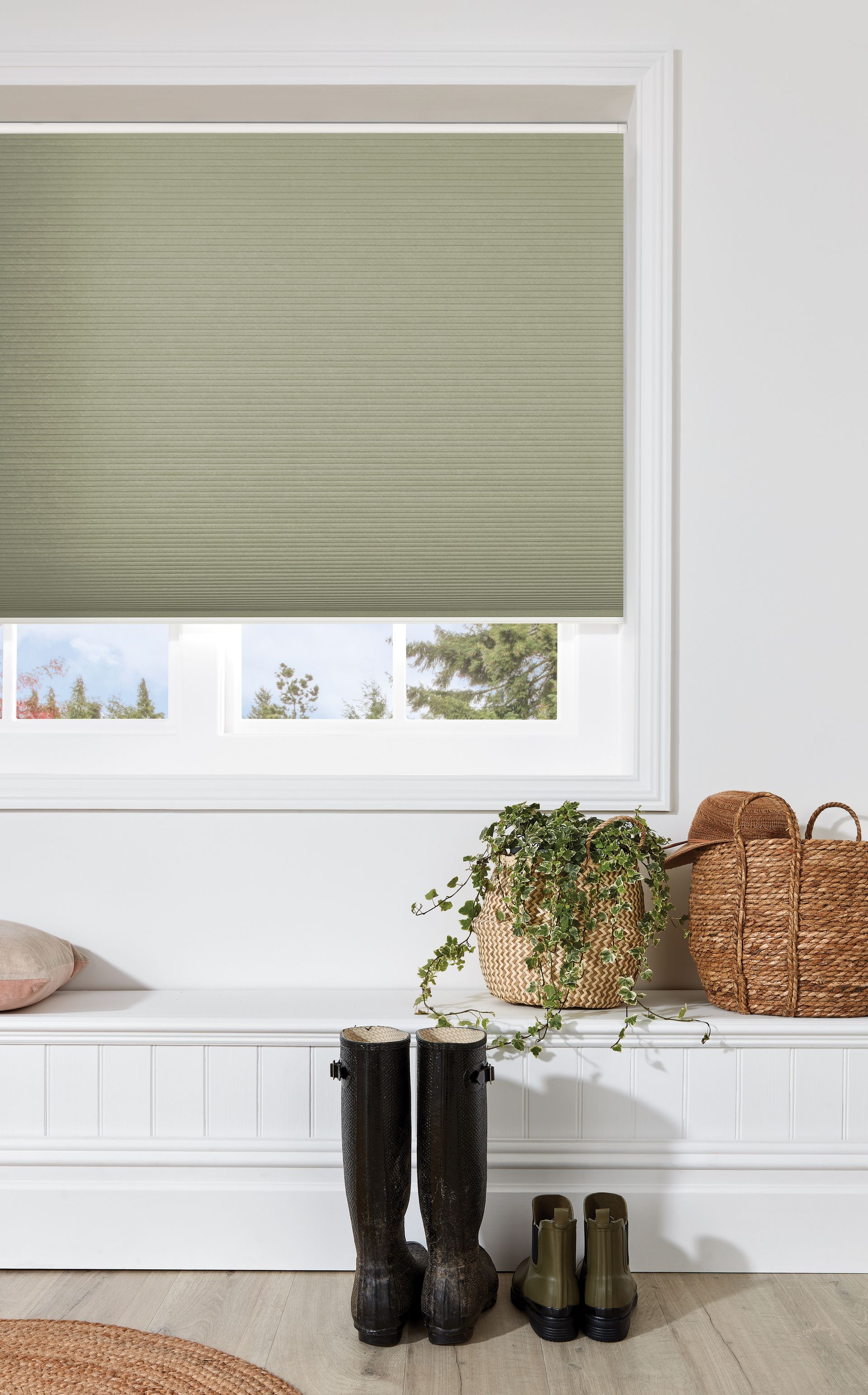 A pair of boots are sitting on a bench in front of a window with a green blind.
