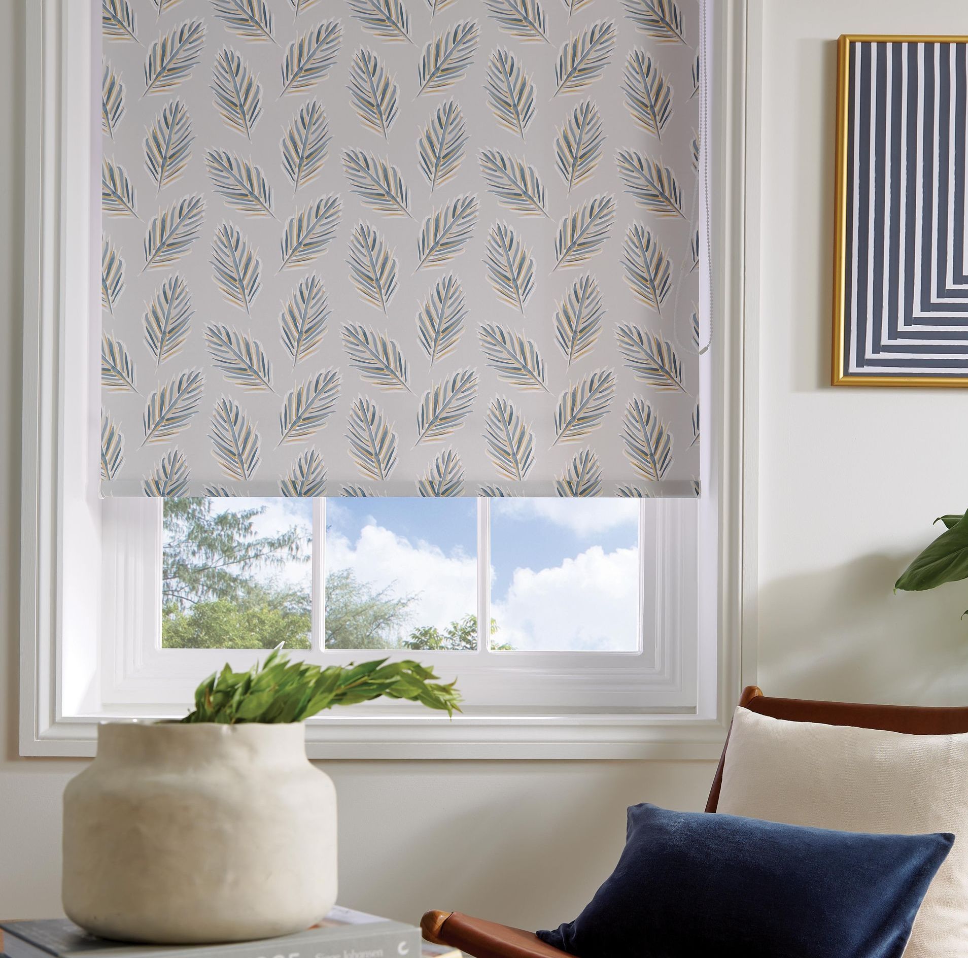 A living room with a chair and a window with a blind on it.