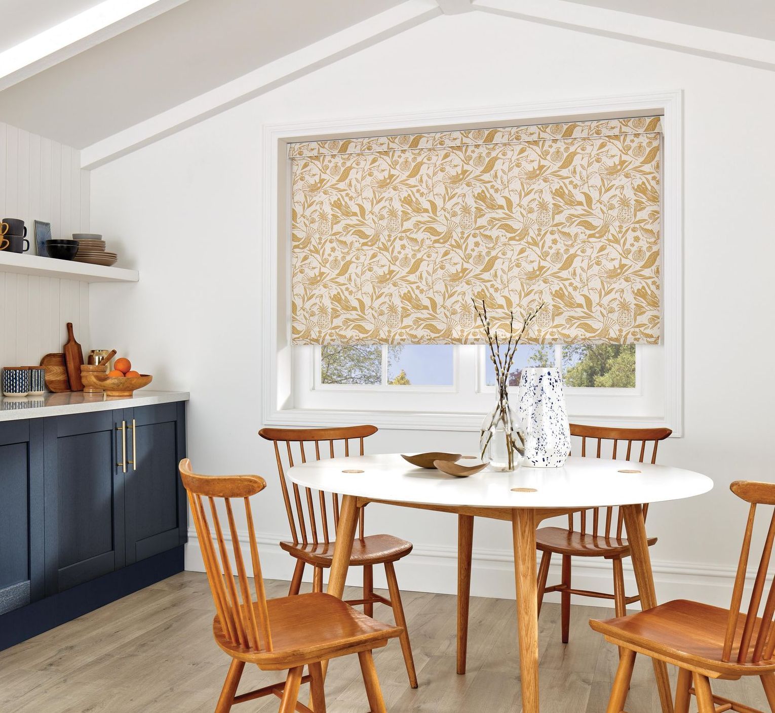 A dining room with a table and chairs and a window with blinds.