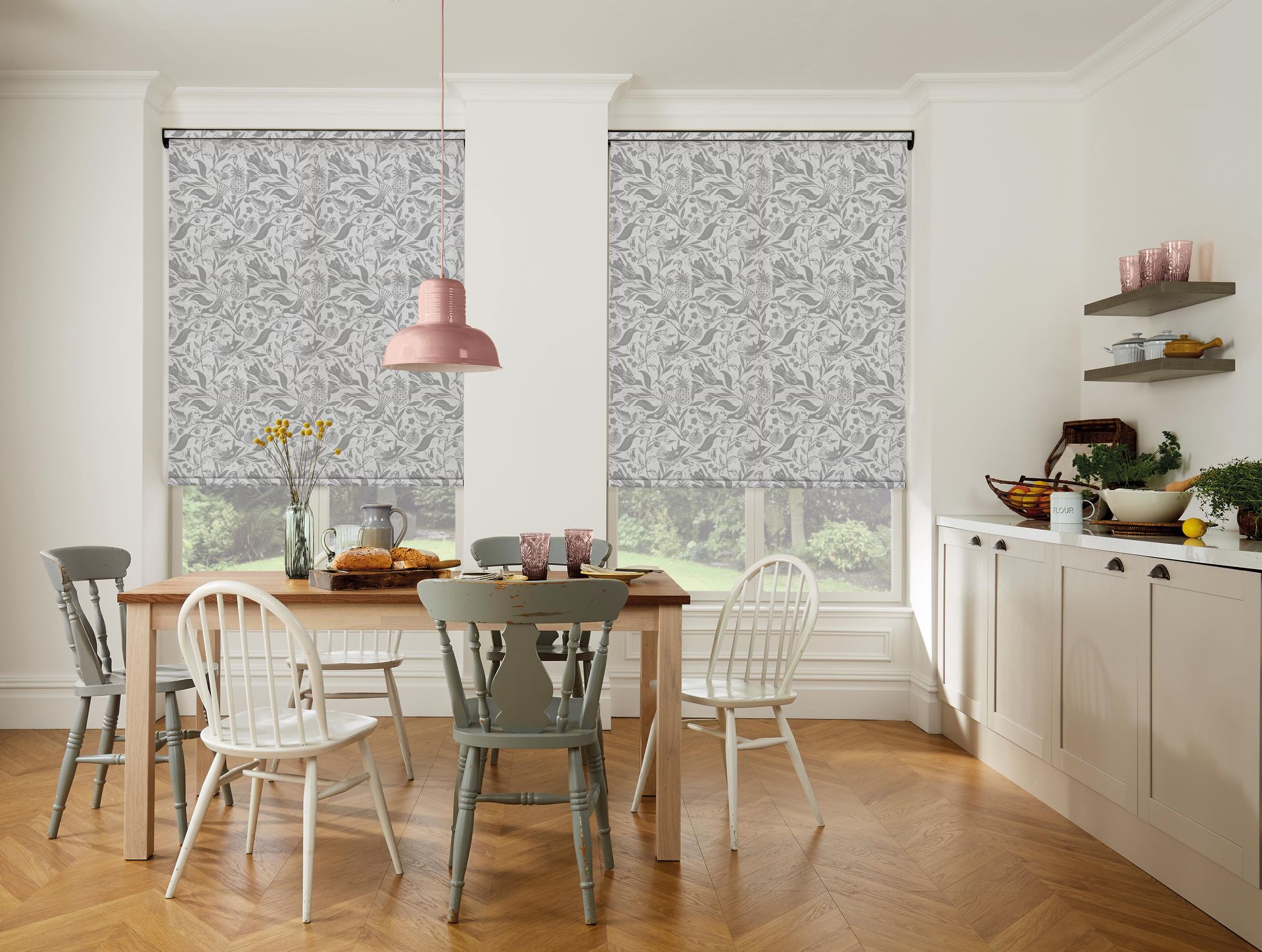 A kitchen with a table and chairs and blinds on the windows.