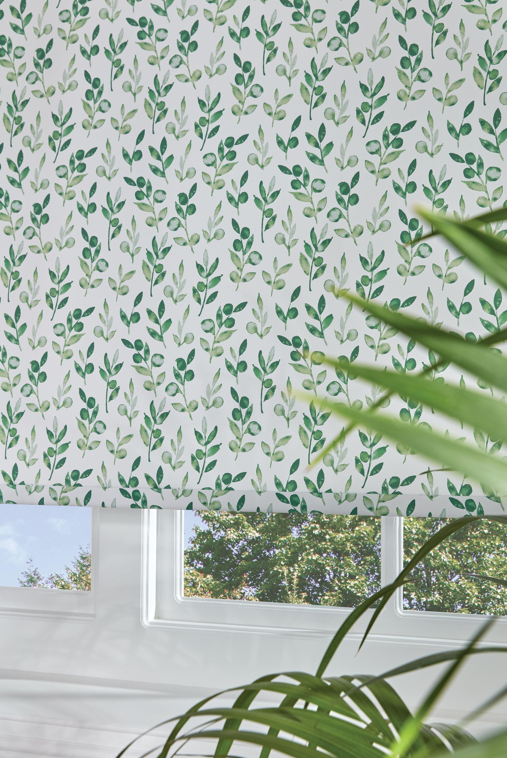 A white wall with green leaves on it