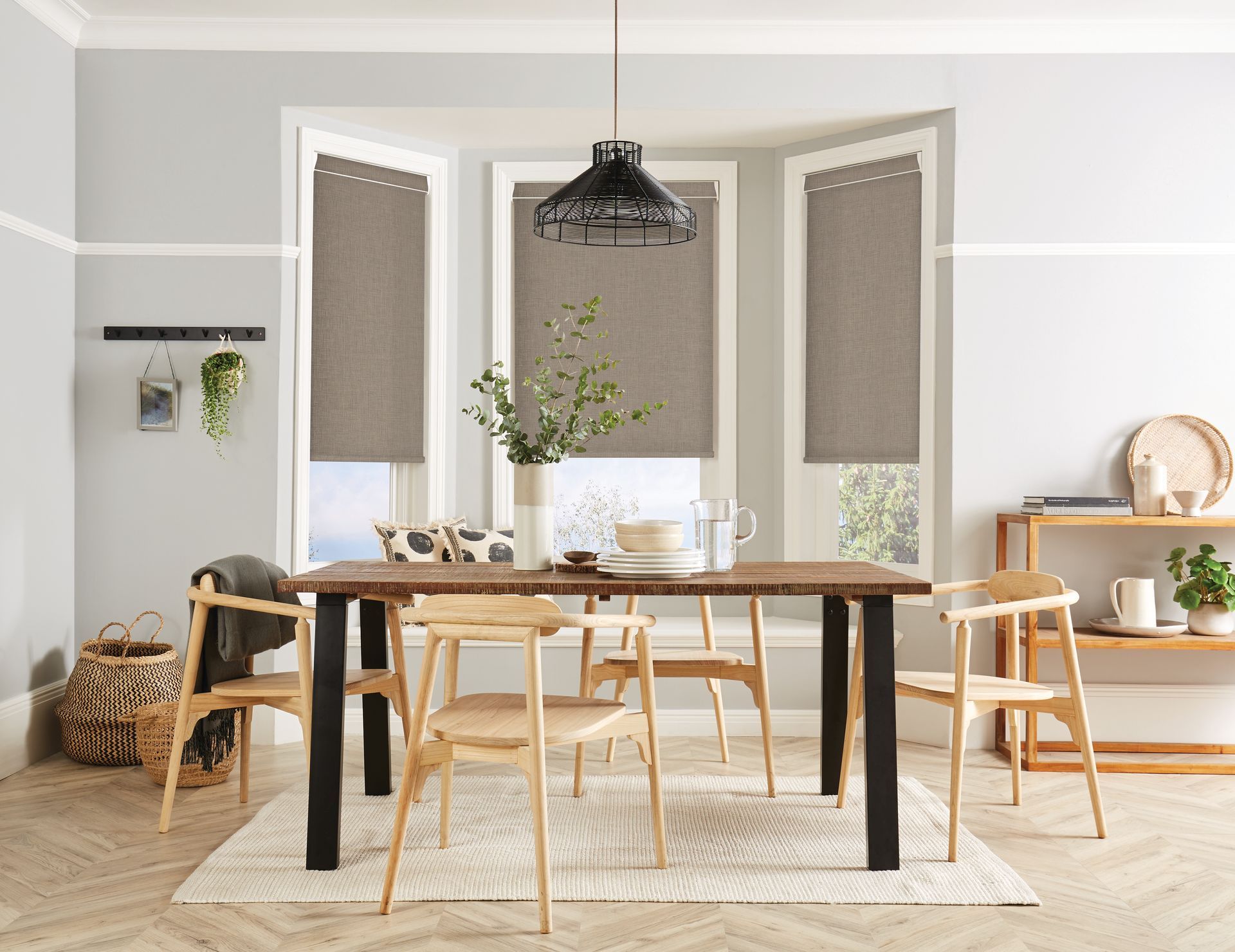A dining room with a table and chairs and blinds on the windows.