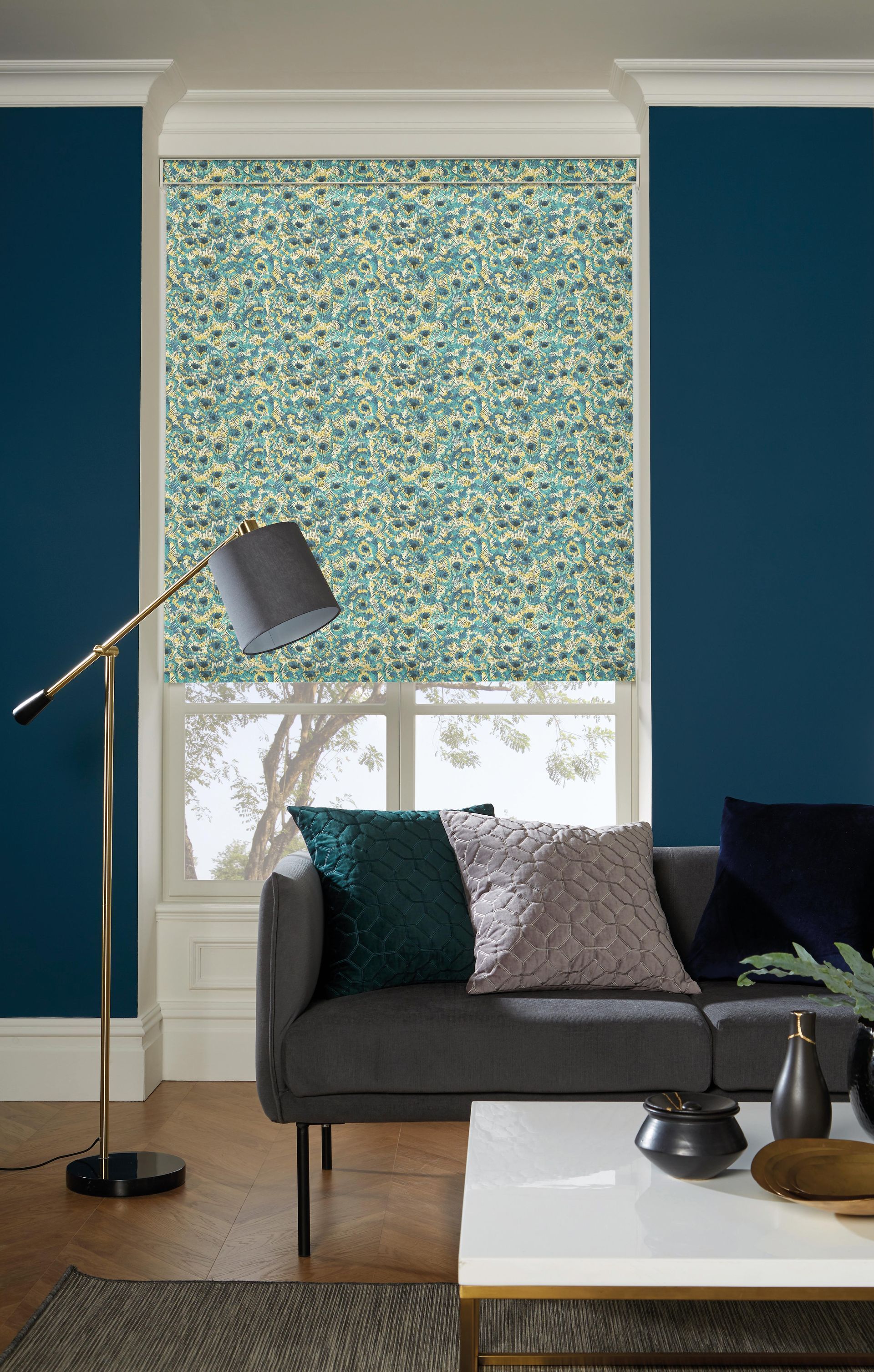 A living room with a couch , table , lamp and window.