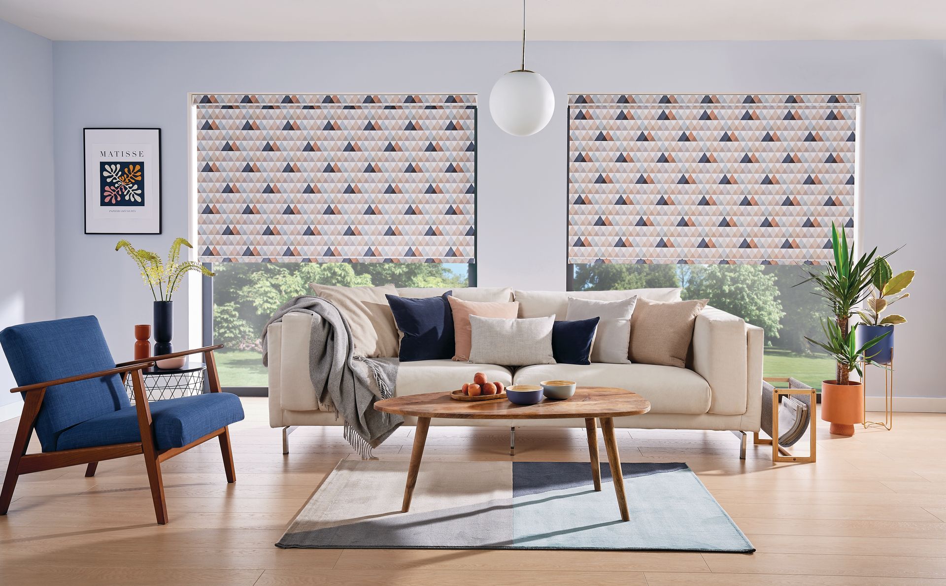 A living room with a couch , chair , coffee table and blinds.