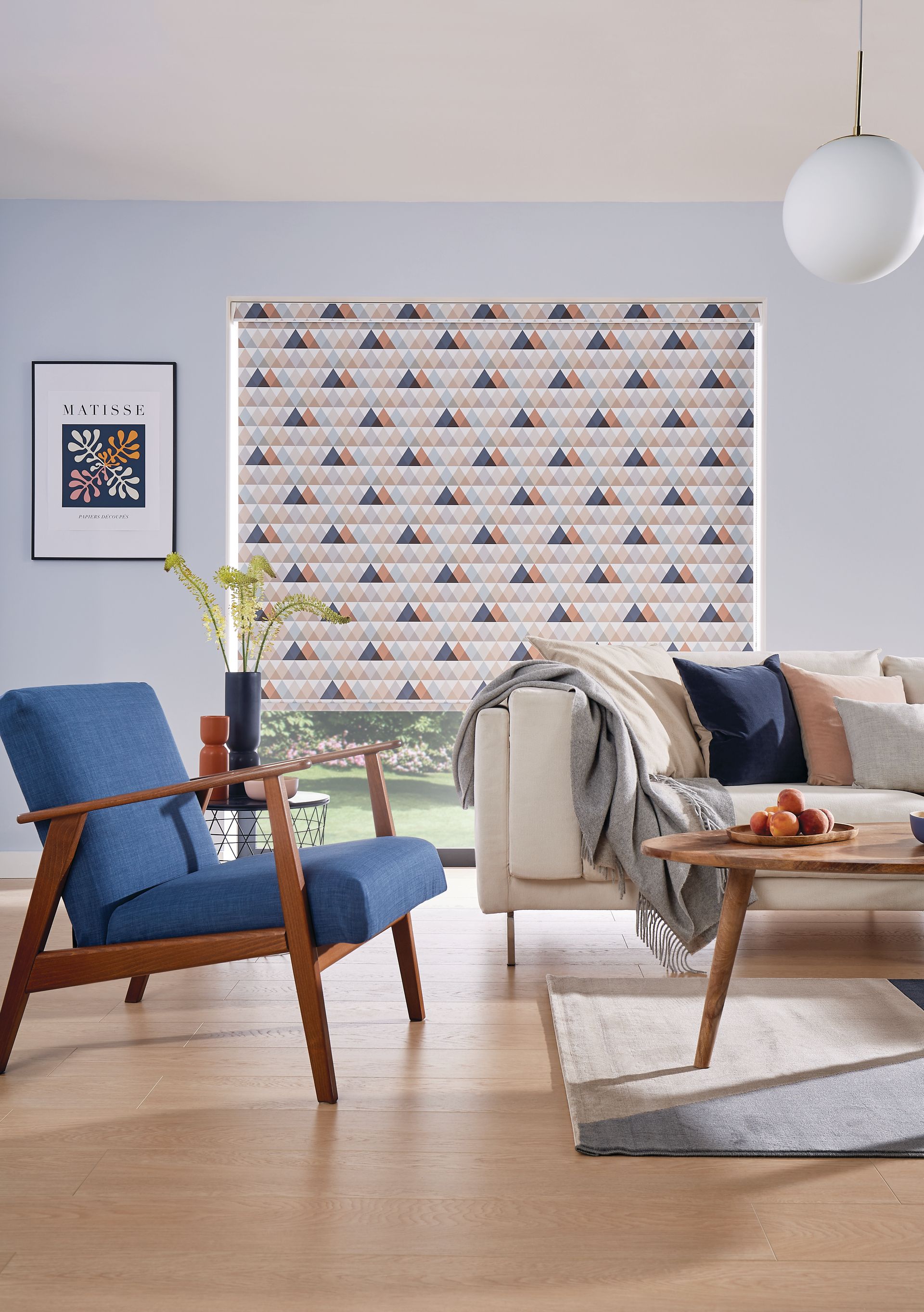 A living room with a couch , chair , coffee table and blinds.