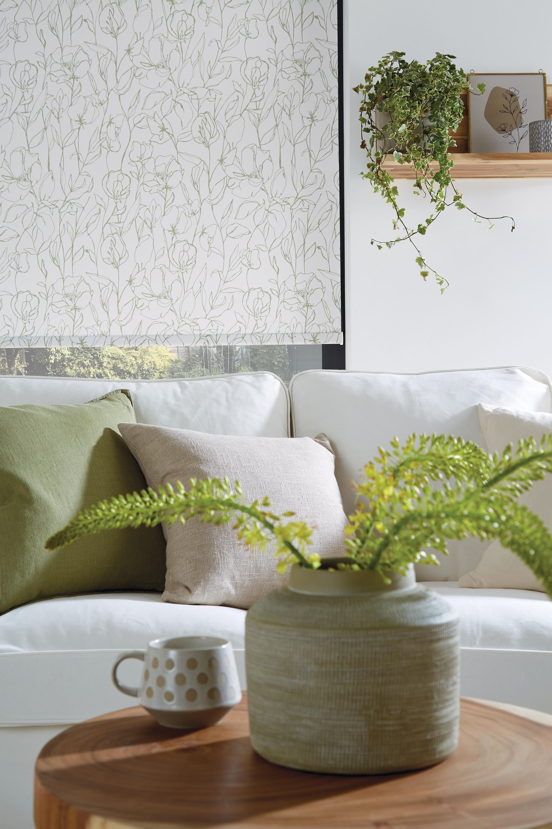 A living room with a white couch and green pillows