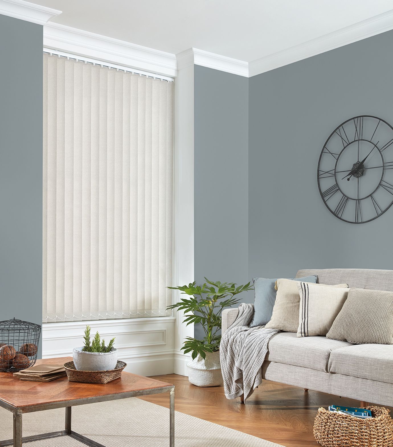 A living room with a couch , table , and clock on the wall.