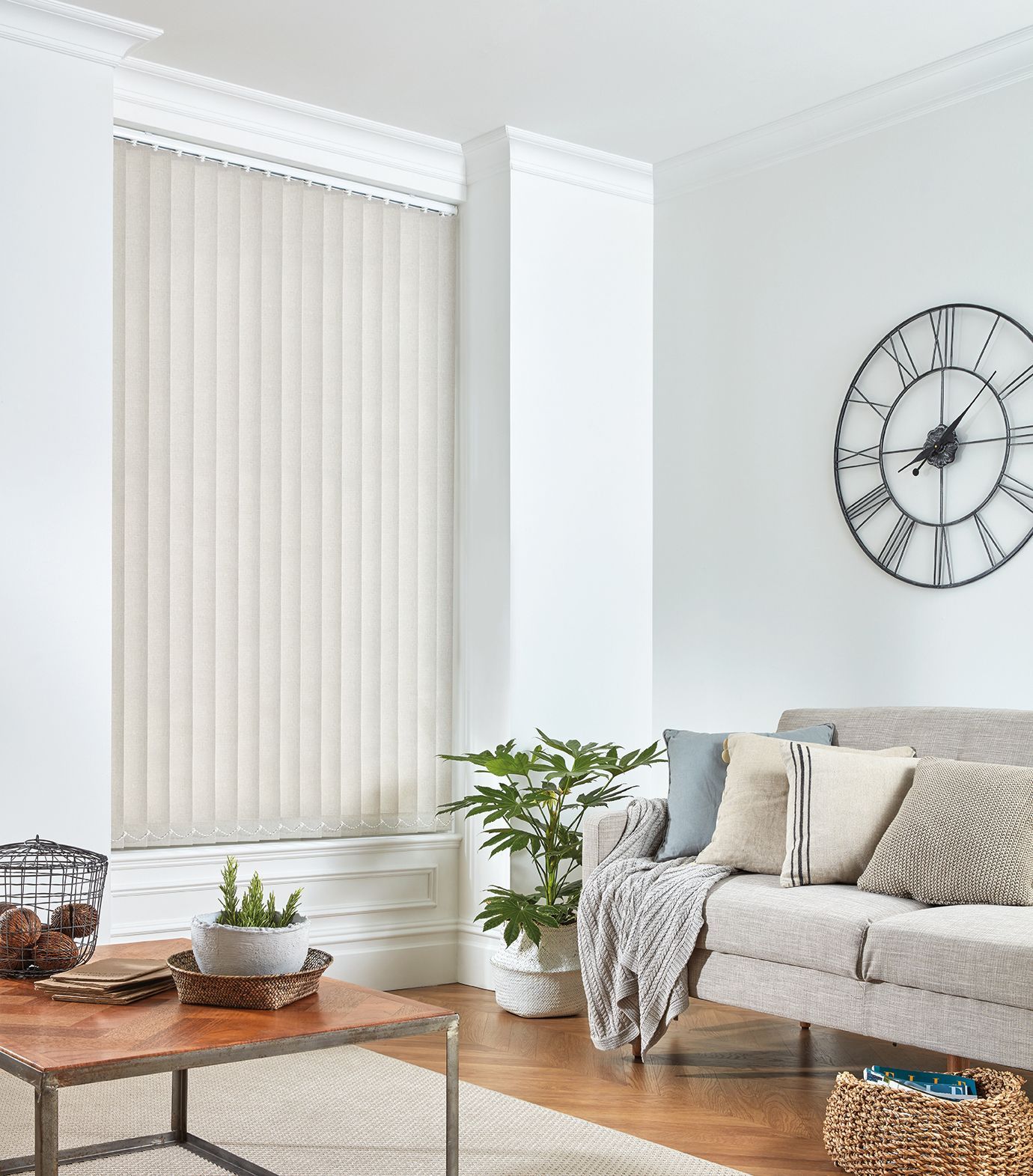 A living room with a couch , table , and clock on the wall.