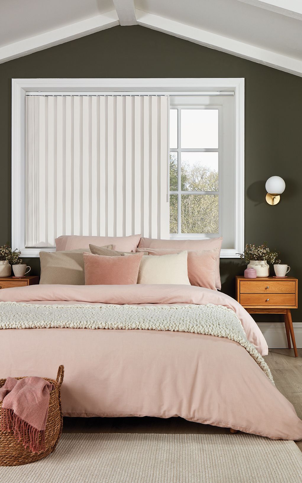 A bedroom with a bed , nightstands , and a window with vertical blinds.