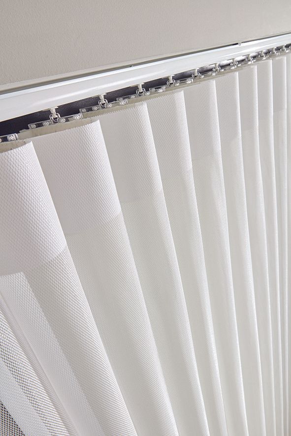 A close up of a white vertical blind on a window.