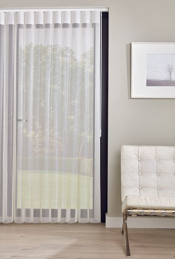 A living room with a sliding glass door and a white chair