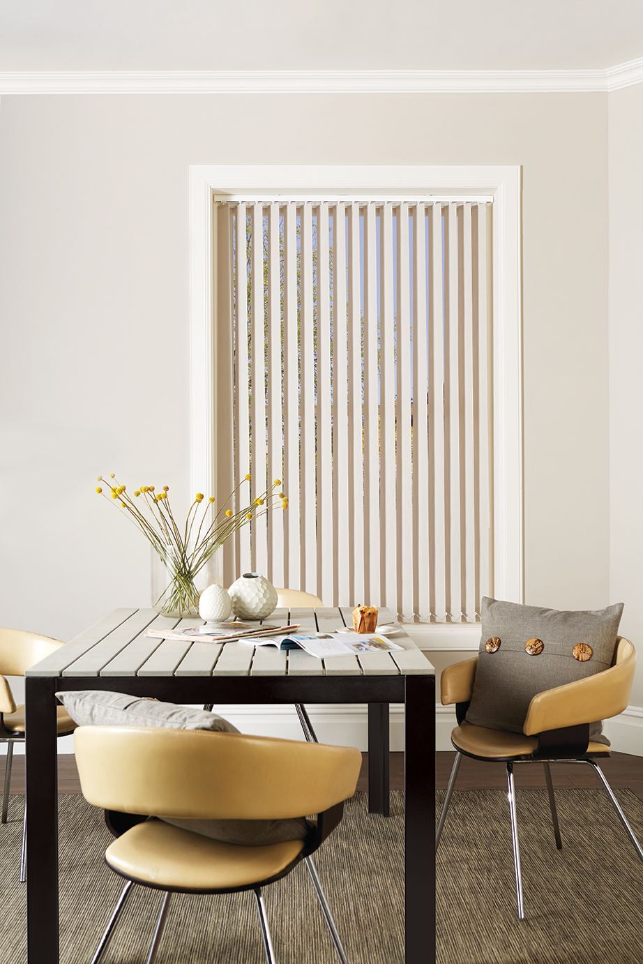 A dining room with a table and chairs and vertical blinds.