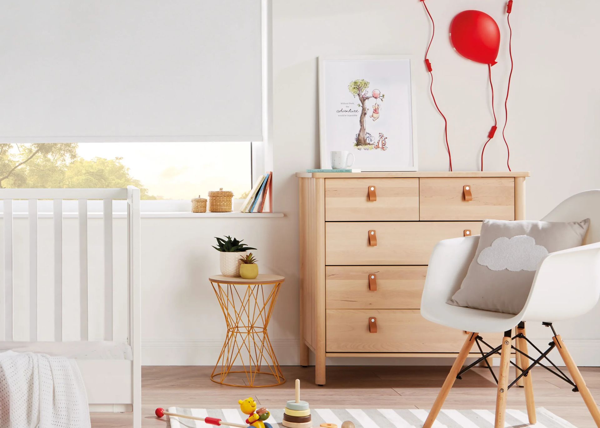 A bright nursery with a crib, chest of drawers, and an open window with a white blind.