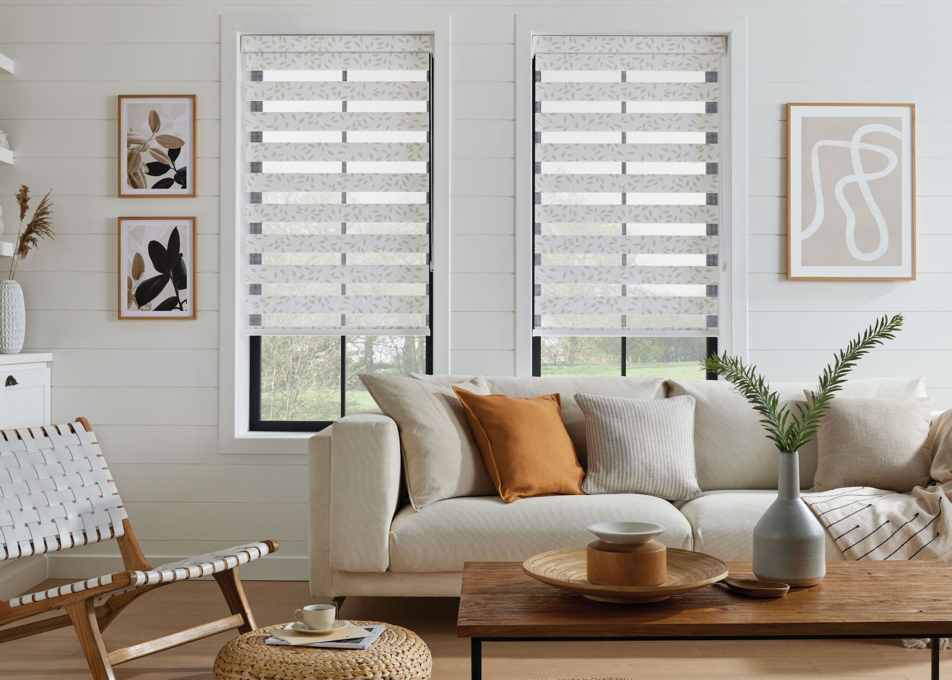 A living room with a couch , chair , coffee table , and blinds.