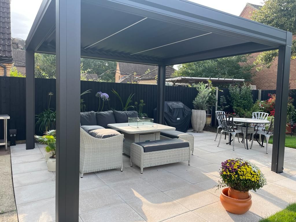 A patio with a table and chairs under a pergola.