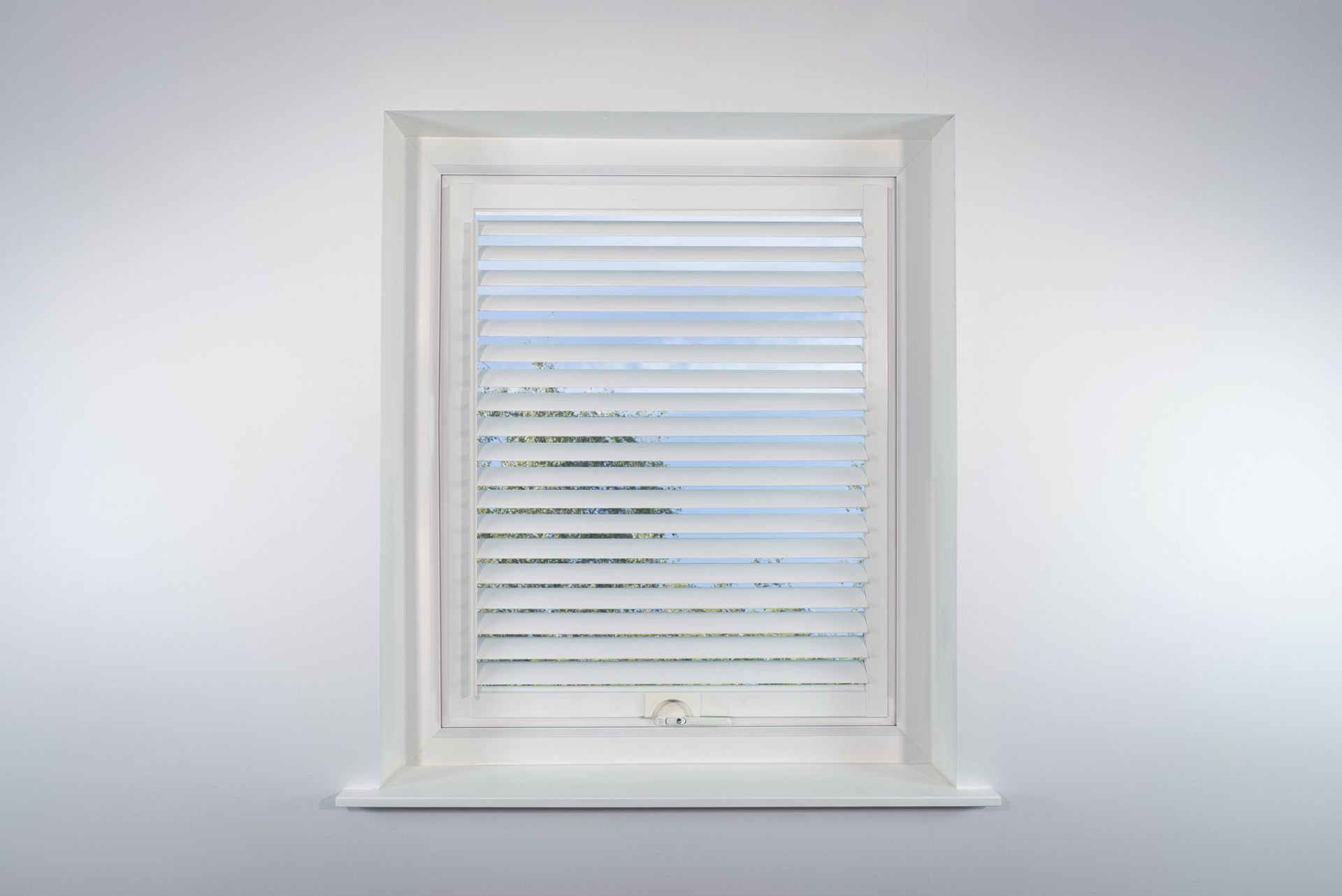 A window with blinds on it is against a white wall.