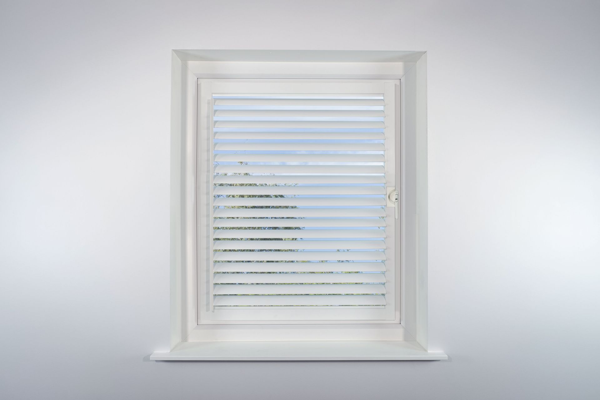 A window with blinds on it is against a white wall.