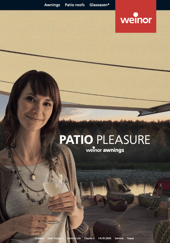 A woman is holding a glass of wine on a patio.