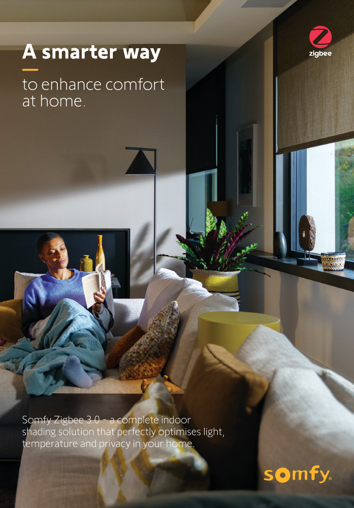 A man is sitting on a couch reading a book.