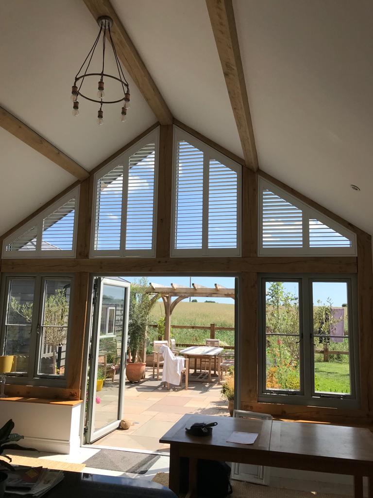 A living room with a lot of windows and a chandelier hanging from the ceiling