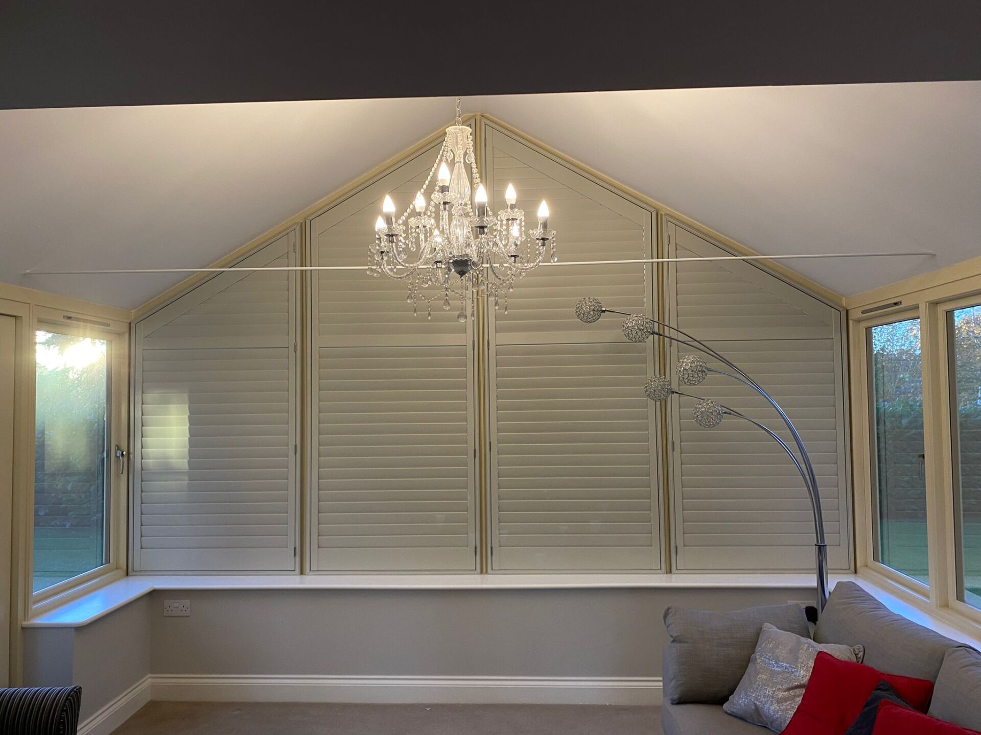 There is a chandelier hanging from the ceiling in the living room.