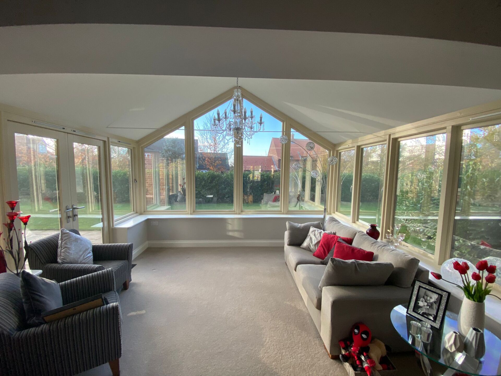 A living room with a couch , chairs , and a chandelier.