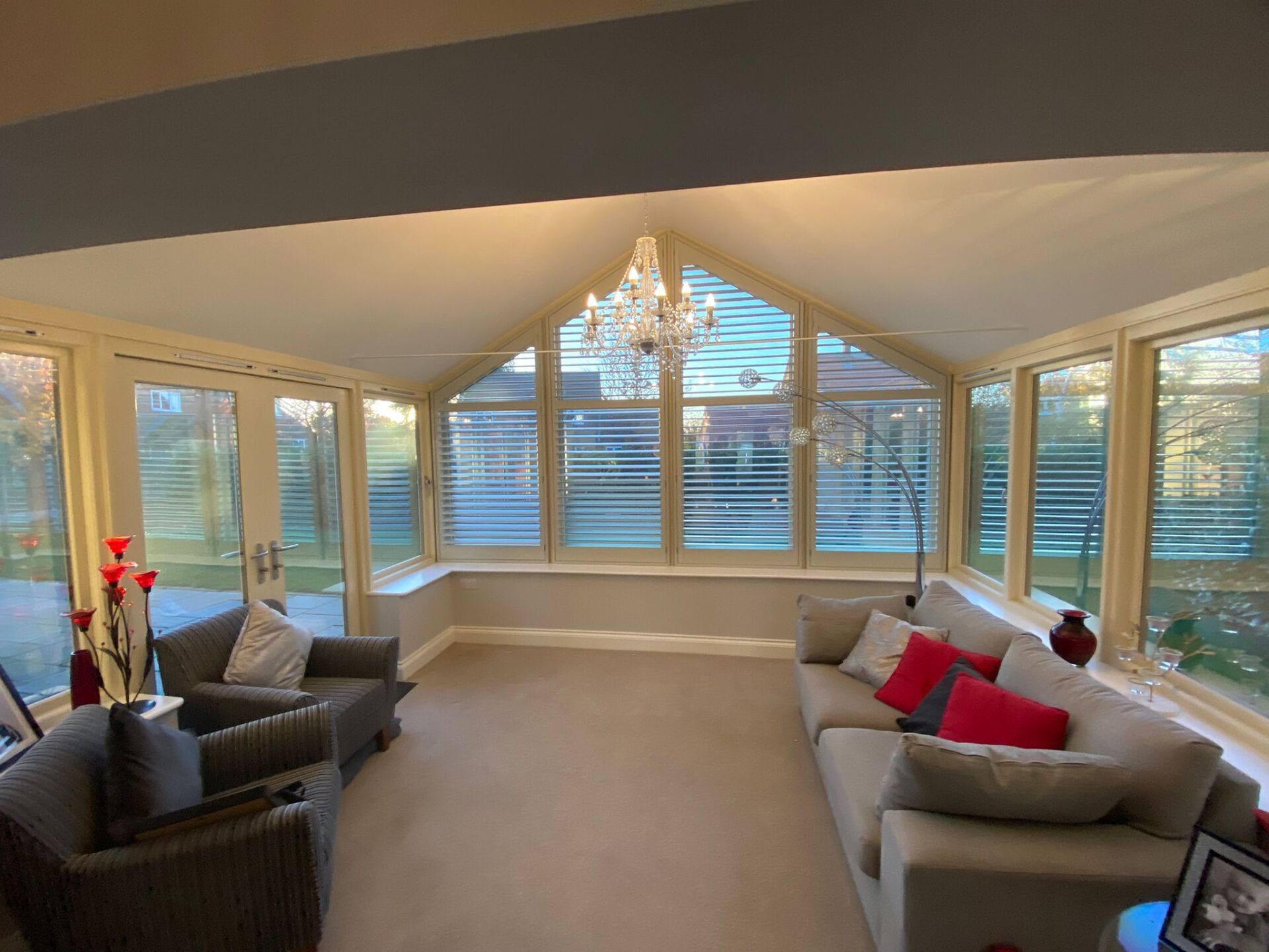 A living room with a couch , chairs and a chandelier.