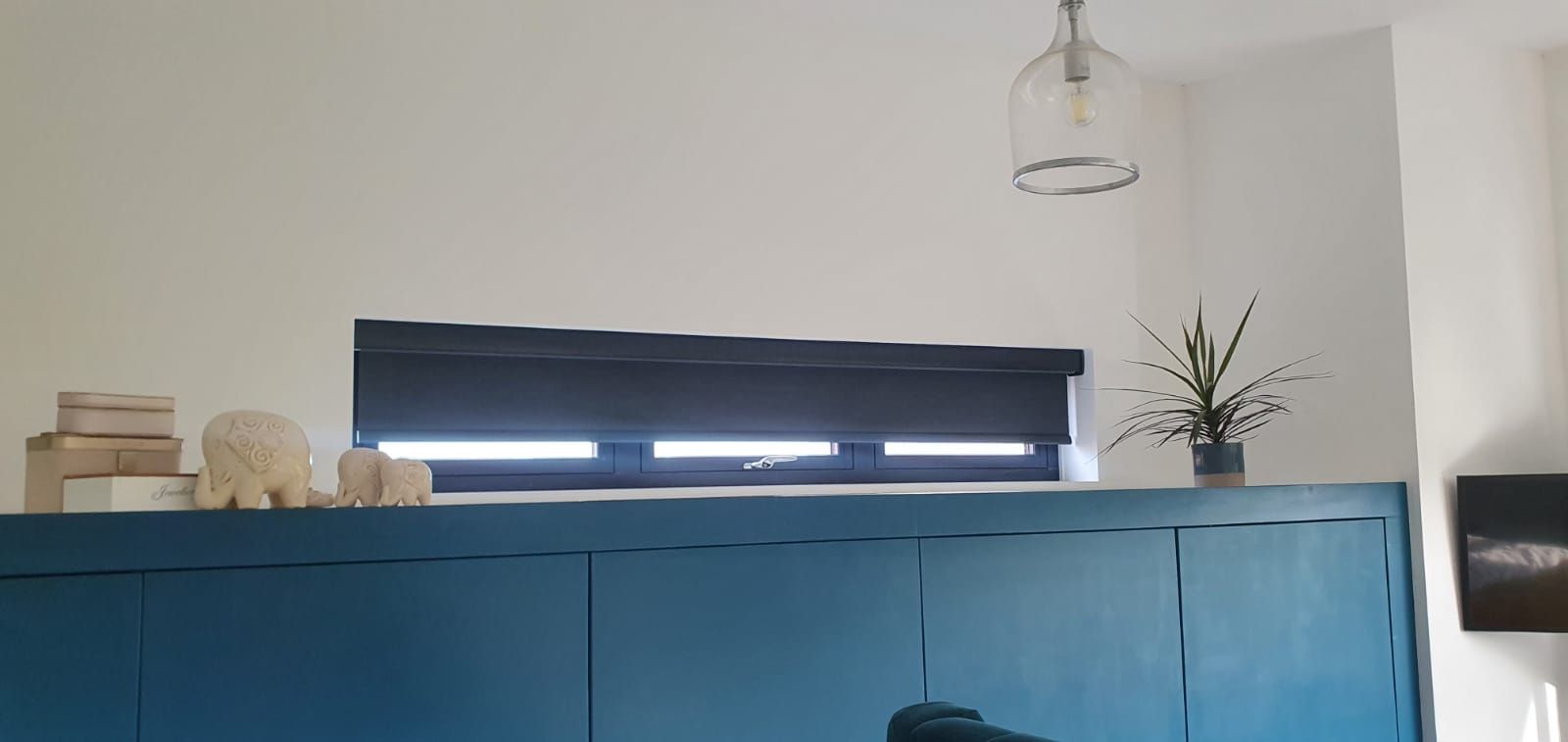 A living room with blue cabinets and a window.