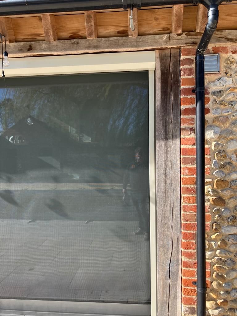 A brick wall with a window and a black pipe