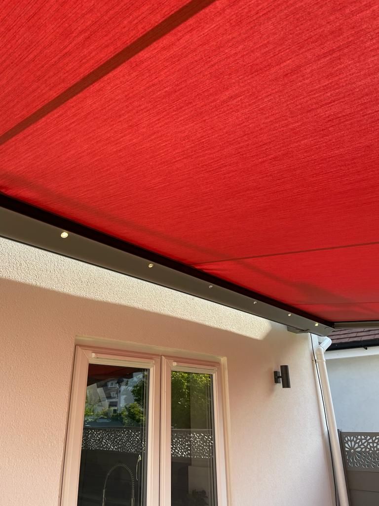 A red awning is covering the roof of a house.
