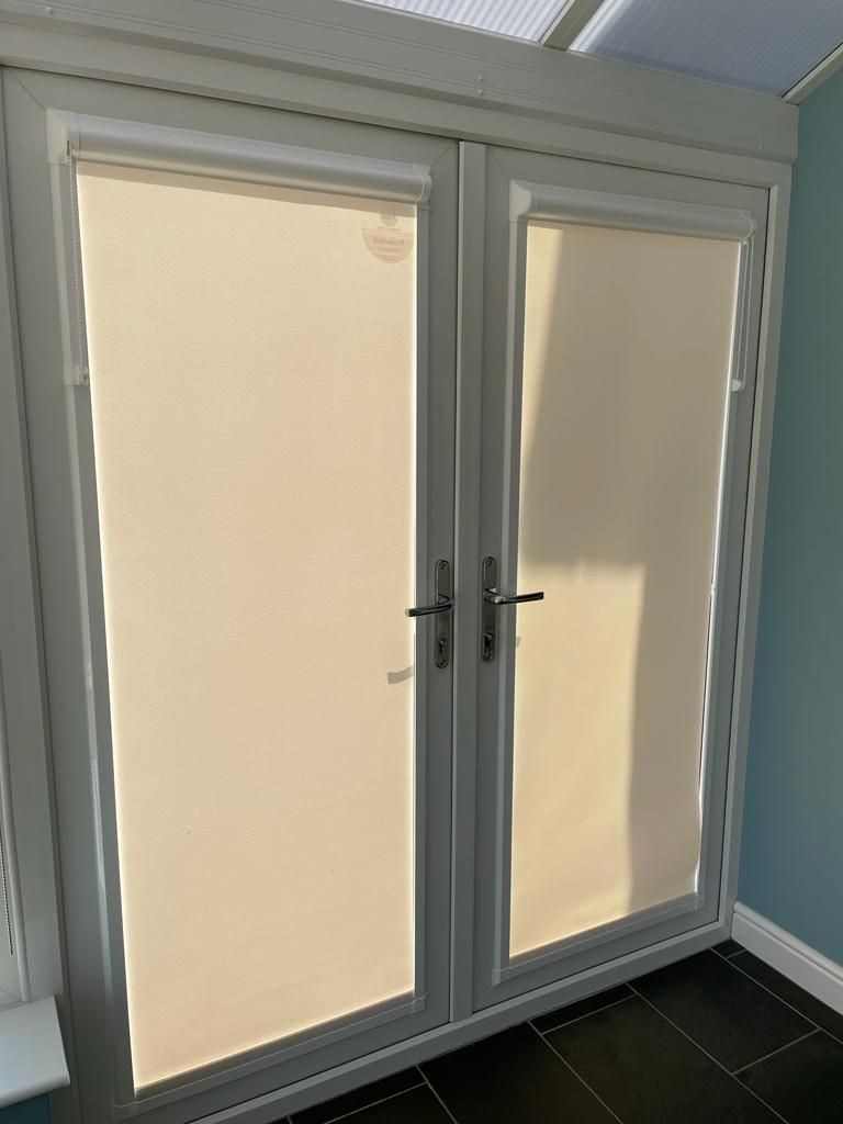 A pair of doors with blinds on them in a room.