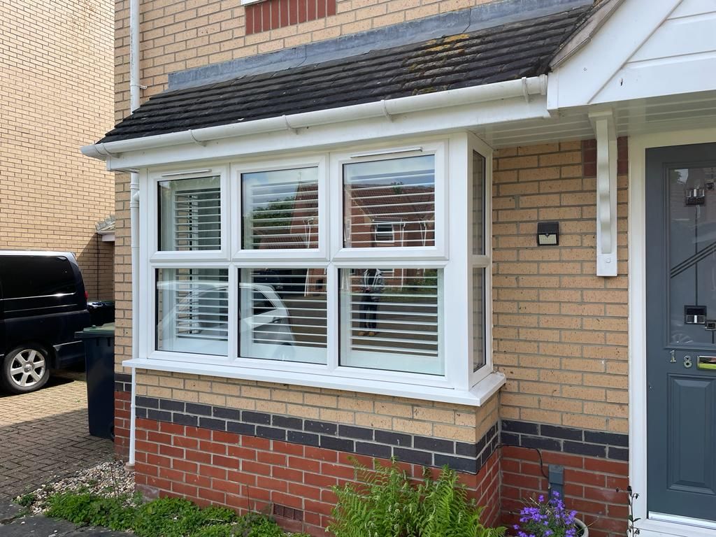 A house with a porch and a car parked in front of it.