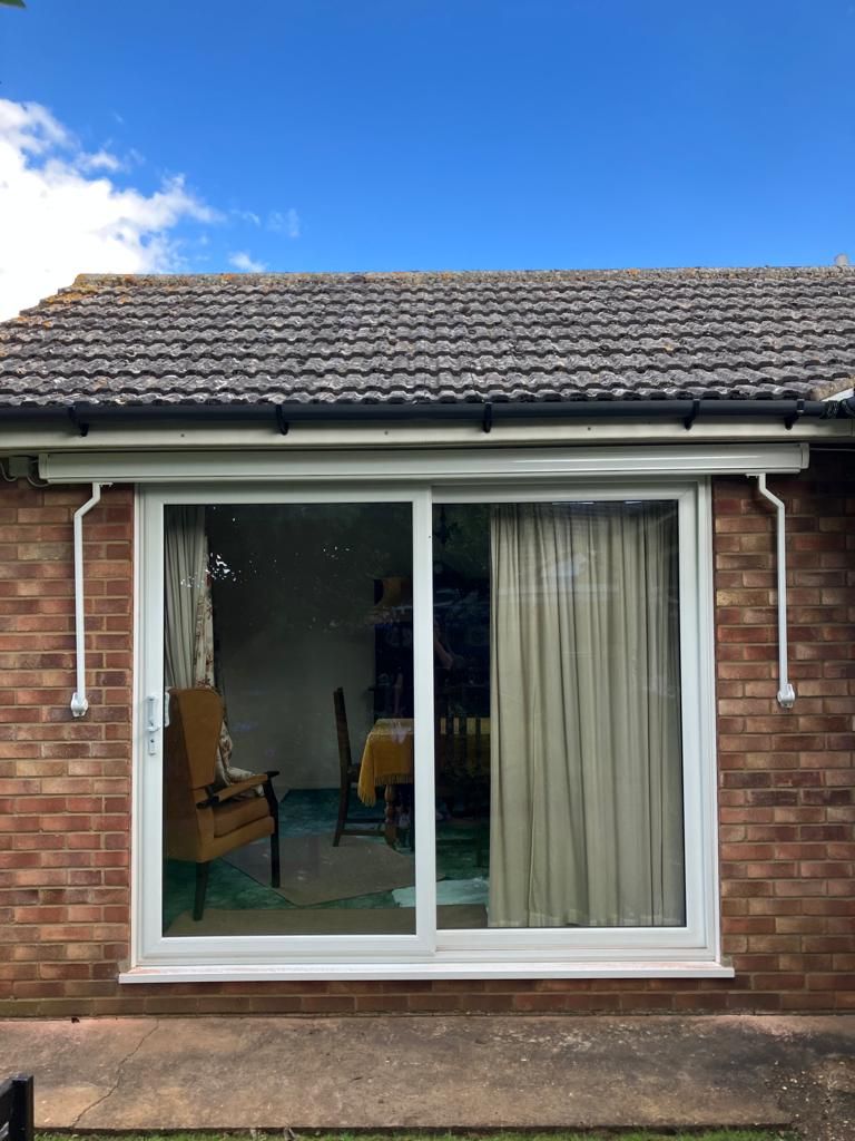 A brick house with a sliding glass door leading to a patio.