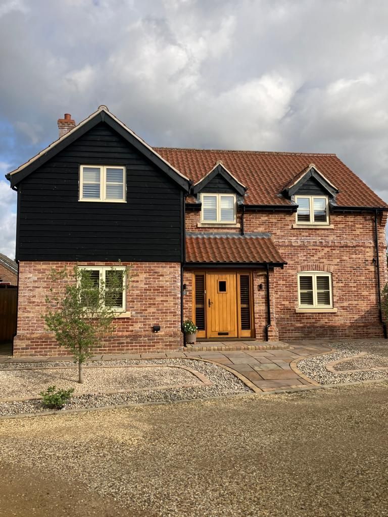 A large brick house with a black roof and a wooden door