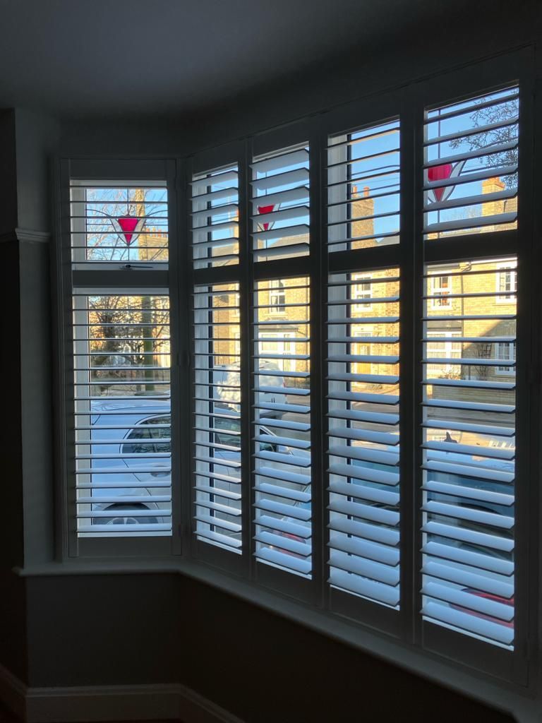 A window with shutters and a stained glass window