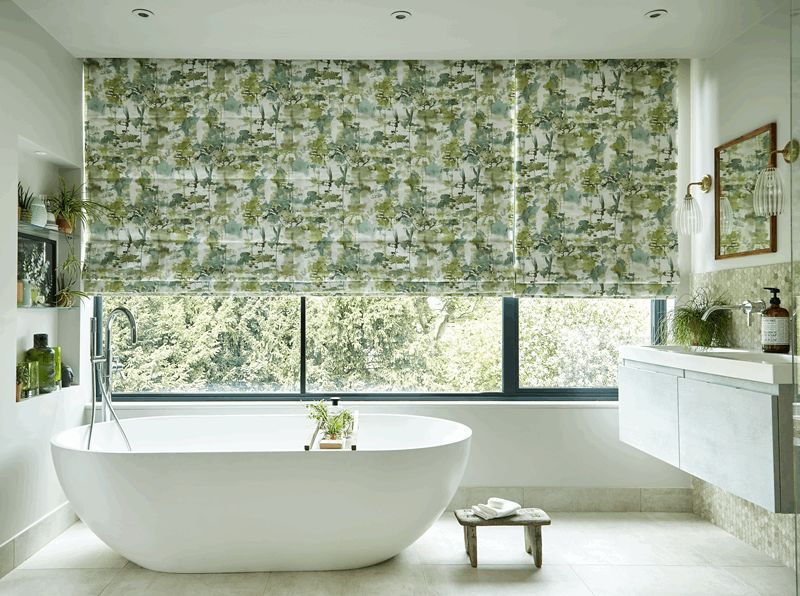 A bathroom with a bathtub , sink , mirror and window.