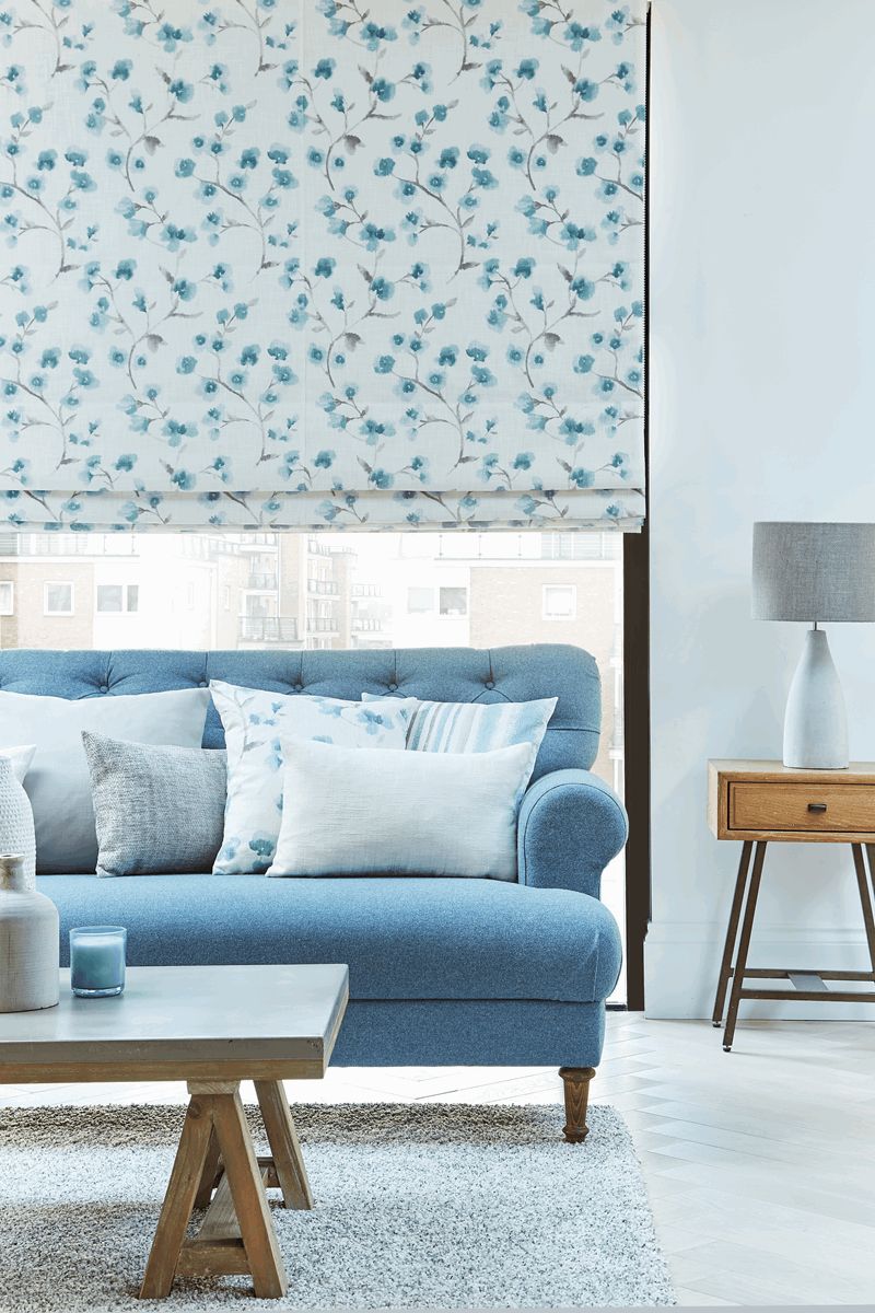 A living room with a blue couch and a white table.