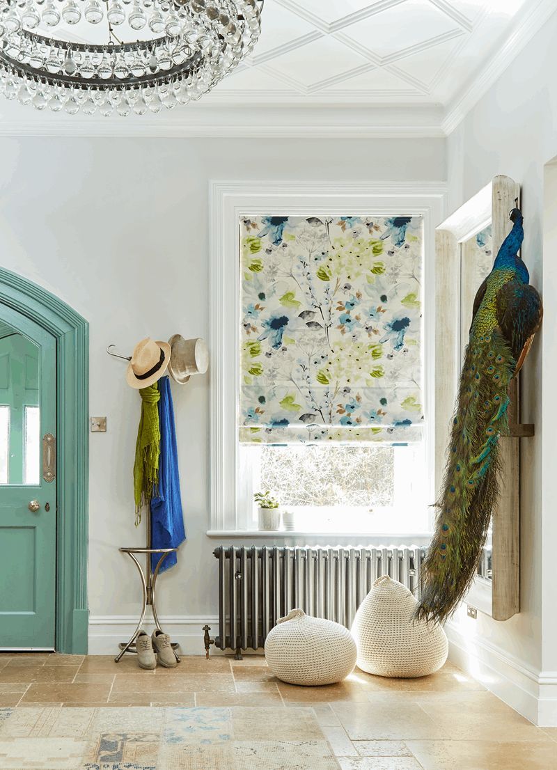 A peacock is hanging on a wall in a hallway.