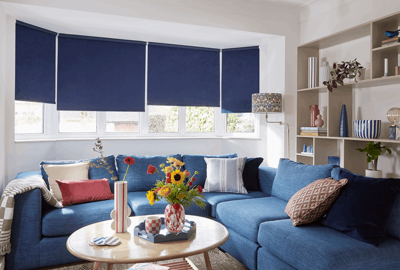 A living room with blue furniture and blue blinds