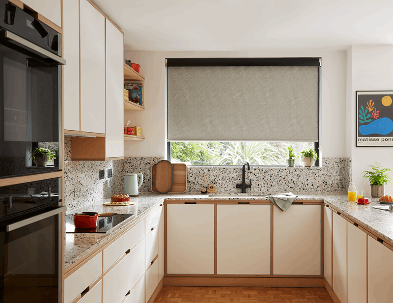 A kitchen with white cabinets , a black oven , a sink , and a window.
