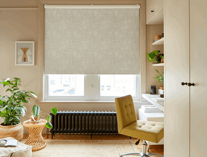 A living room with a desk , chair , table and window.