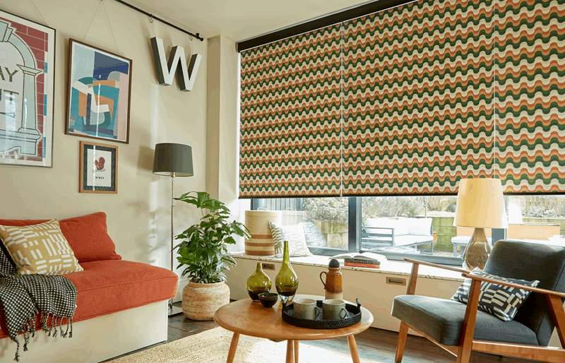 A living room with a couch , chair , table and window.