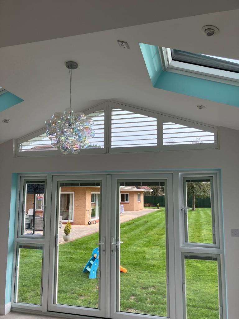 A room with a lot of windows and a chandelier hanging from the ceiling.