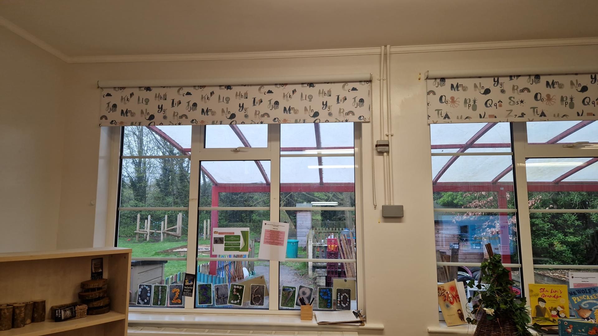 A room with a lot of windows and a christmas tree on the window sill.