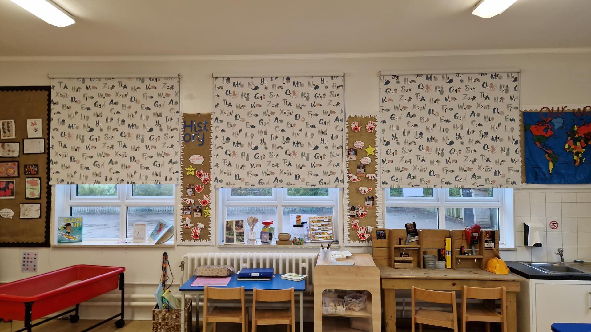 A classroom with tables and chairs and a map of the world on the wall.