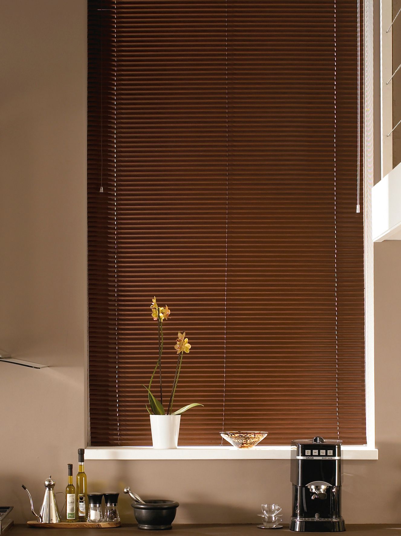 A kitchen with brown blinds and a coffee maker