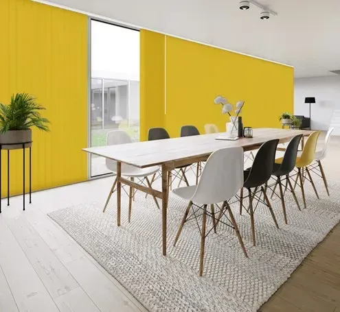 A dining room with a table and chairs in front of a yellow wall.